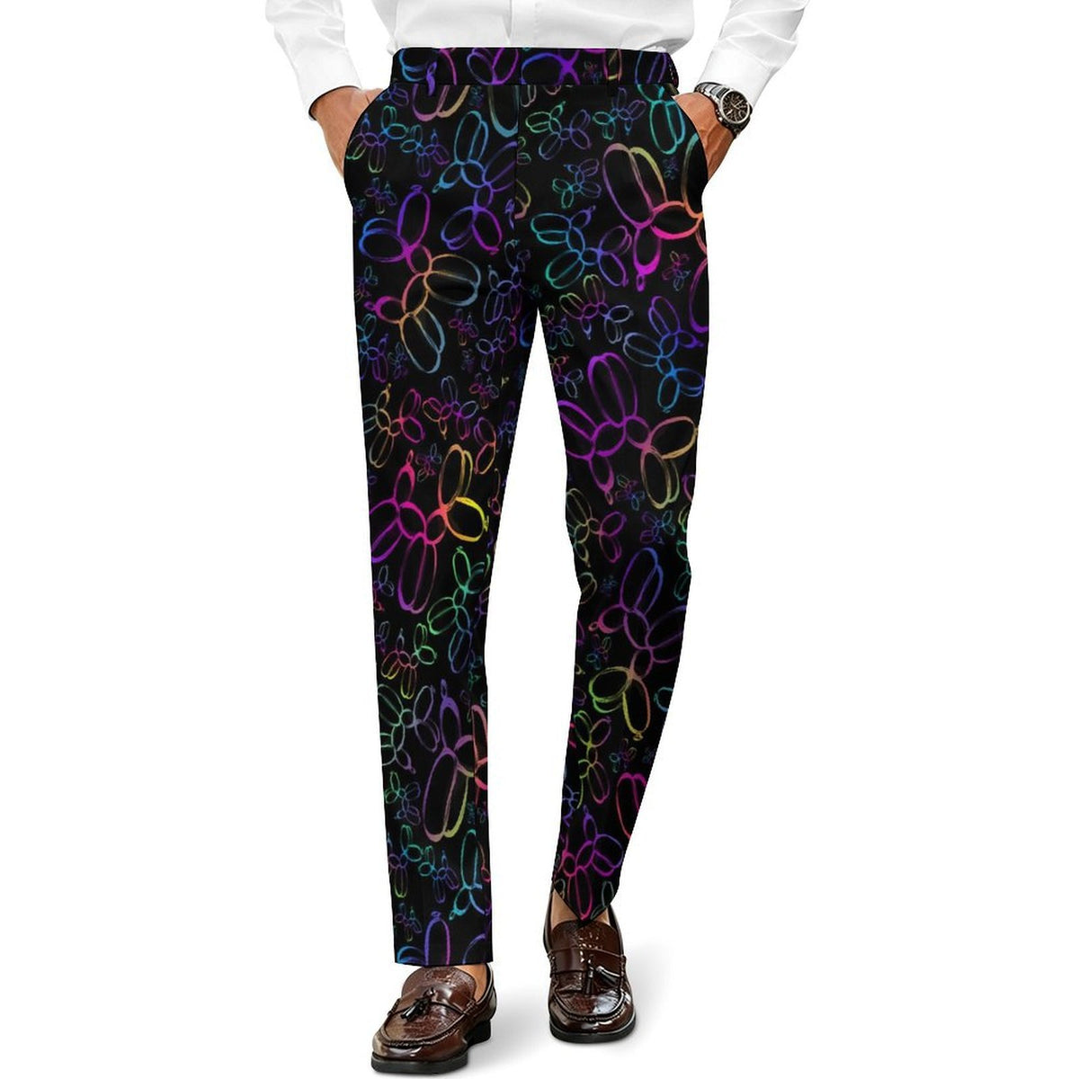 A person wearing slim black trousers with a colorful neon balloon-bloon pattern, paired with a white dress shirt and brown loafers, shown from the waist down on a white background.