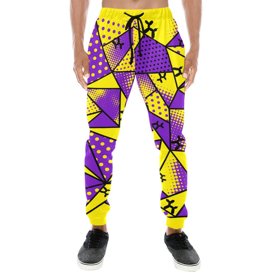A person wearing bright yellow and purple geometric jogger pants with black drawstrings and black sneakers, shown against a plain white studio background.