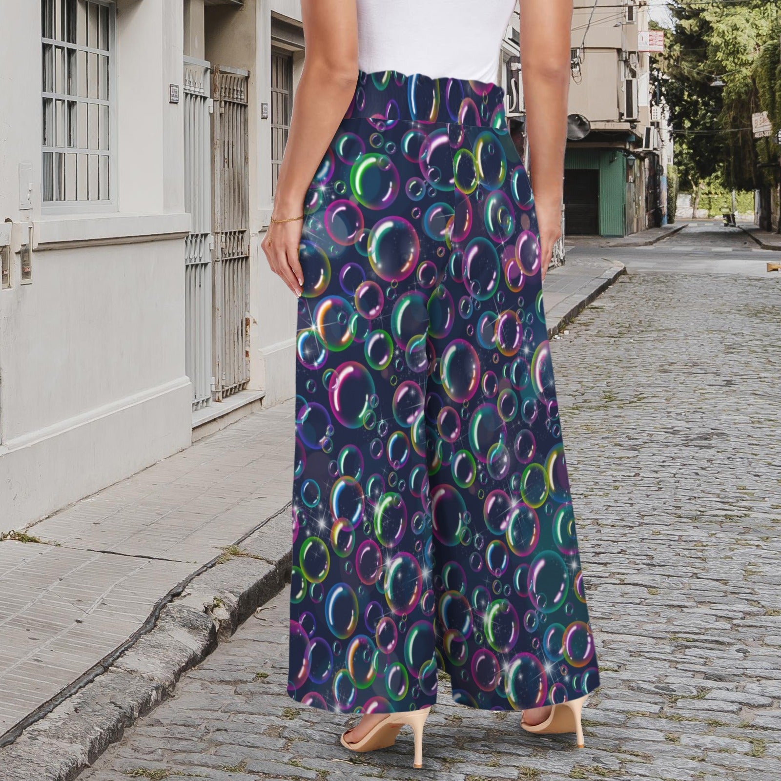 Person wearing colorful bubble-patterned pants on a street.