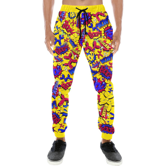 A person wearing bright yellow jogger-style pants covered in a dense multicolor graffiti-style print with red, blue, purple, and pink lettering, shown against a plain white background.